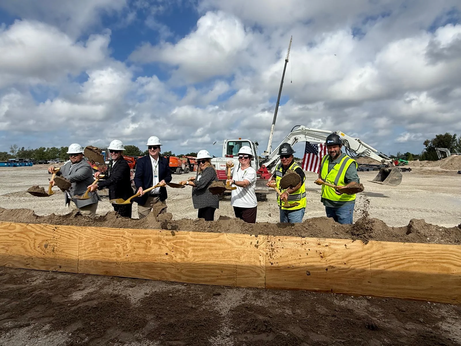 Participants holding ceremonial shovels during a construction groundbreaking