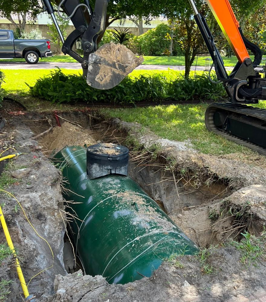 Mini excavator working beside a partially installed underground tank in Southwest Florida
